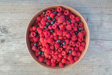 Bowl full of raspberries and blueberries, top view