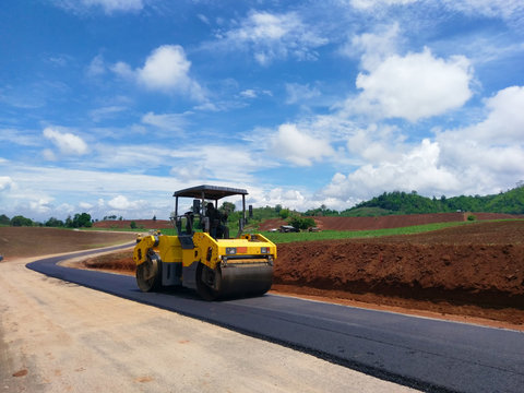 Road rollers building the new asphalt road and working on new road construction site.
