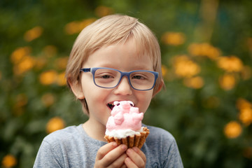 a happy child, a boy of 4-5 years old, is eating a delicious cake in the form of a pig