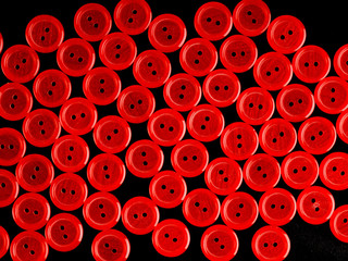 Red plastic buttons on black background