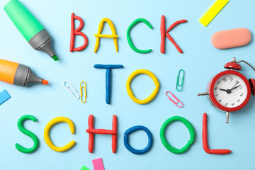 School supplies and inscription back to school on color background