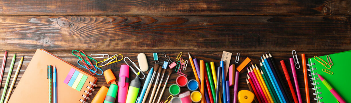 Flat lay composition with school supplies on wooden background, space for text