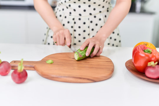 Woman Chopping Vegetables In Her Kitchen