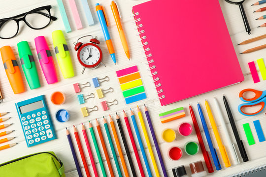 Flat lay composition with school supplies on white wooden background