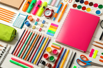 Flat lay composition with school supplies on white wooden background