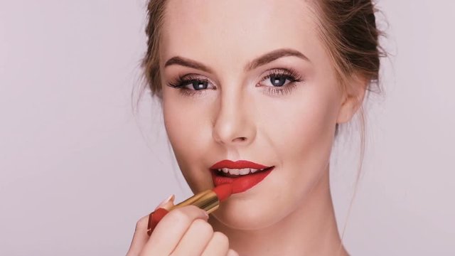 sexy lady doing make-up with red lipstick