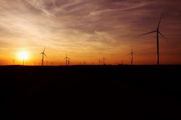 Fototapeta premium Wind Turbines Over Sunset Sky Generating Electricity. Sustainable Energy Power Generators, Renewable Power Supply