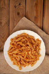 white plate with pasta on a wooden table
