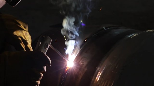 Manual arc welding of large diameter pipeline elements. Welding works are carried out in workshop conditions