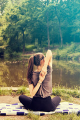 Beautiful woman meditating by the water
