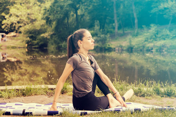 Beautiful woman meditating by the water