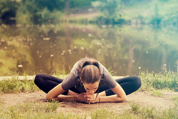 Beautiful woman meditating by the water