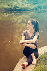 Beautiful woman meditating by the water