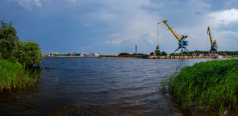 Fototapeta premium storm clouds forming over Riga cargo shipping port on river Daugava