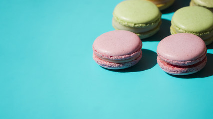 Pink and green macaroons on turquoise backdrop