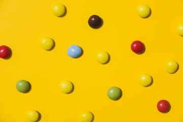 Colorful candies on yellow backdrop