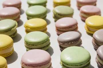 Row of macaroons arranged on white backdrop