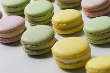 Row of fresh tasty macaroons on white backdrop