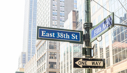 Fototapeta na wymiar 5th ave and E38 corner. Blue color street signs, Manhattan New York downtown