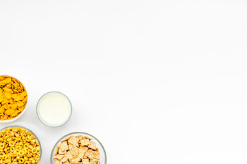 cereals, oatflakes and cornflakes with milk for healthy breakfast on white background top view mock up