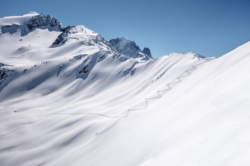 Fototapeta na wymiar Single ski touring track leading up alpine mountain slope
