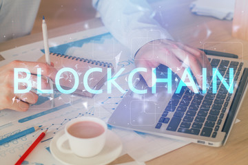 Crypto currency theme hologram with businessman working on computer on background. Concept of...