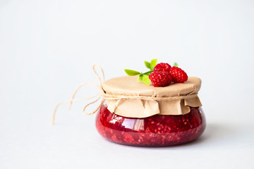 healthy fresh raspberries, homemade jam in a jar