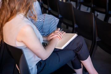woman sitting listening with notebook and pen
