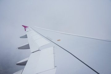 An airplane window view of wing and flaps 