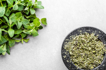 Fresh organic mint leaves or peppermint and dry mint in mortar, top view
