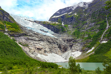 Landscape with river near Briksdal or Briksdalsbreen glacier in Olden, Norway with green mountain. Norway nature and travel background. Summer in Norway, glacier Briksdalsbreen