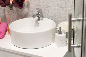 bathroom sink with faucet and soap dozer.