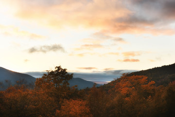 Wooded mountains and pink clouds on the peaks at sunset. White Mountain National Park. USA. New Hamshire.