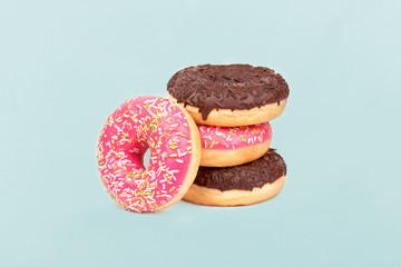 Multicolored donuts glazed on pastel blue background