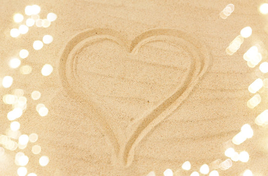 valentine's day, love and summer holidays concept - picture of heart in sand on beach