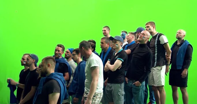 GREEN SCREEN CHROMA KEY 3/4 view group of people fans wearing blue clothes watching a sport event. 4K UHD ProRes 422 HQ