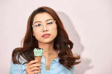 Young asian woman on light pink background. Stylish young woman with ice cream isolated