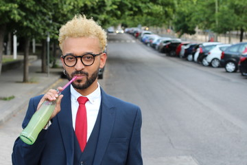 Hip afro businessman drinking a soda outdoors 
