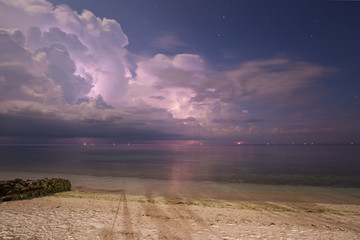 dramatic clouds scape in a thunderstorm with lightnings in the dark night sky photography with long...