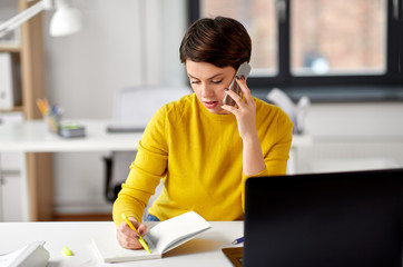 business, technology, communication and people concept - businesswoman with pen and notebook...