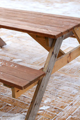 wooden street table and  benches for picnic outdoors in winter on snowy ground