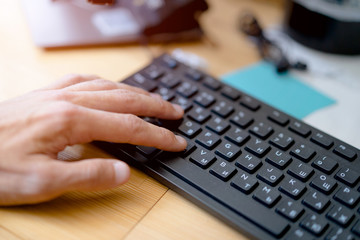 hand on computer keyboard. close-up. sunny. work palce.