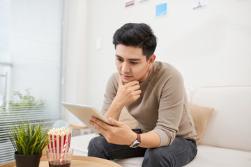 handsome man surfing on tablet on a couch