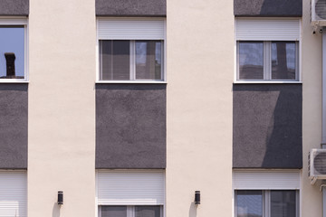 Fragment of a low-rise new building with fresh plaster and windo