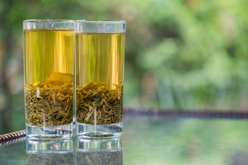Two glasses of green tea on a table in a garden in China
