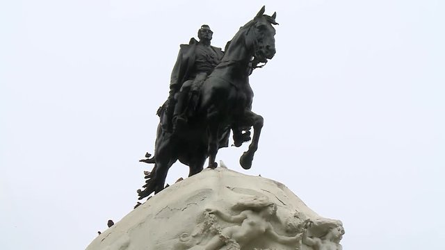 Steady, exterior, low angle, medium close up shot of a soldier riding a horse statue.