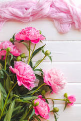 Pink peony flowers on white wooden table. womans day or wedding background.