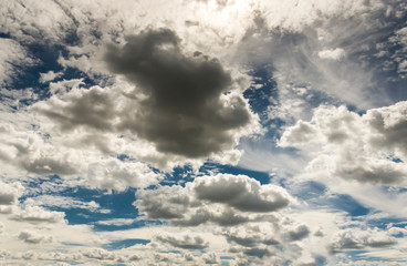 Dramatischer Wolkenhimmel mit dunklen Regenwolken und Sonne vor und nach Gewitter