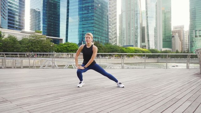 Young asian fitness woman runner stretching legs before run