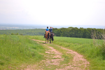 Fototapeta na wymiar Deux cavaliers à cheval dans la campagne, Alsace, France